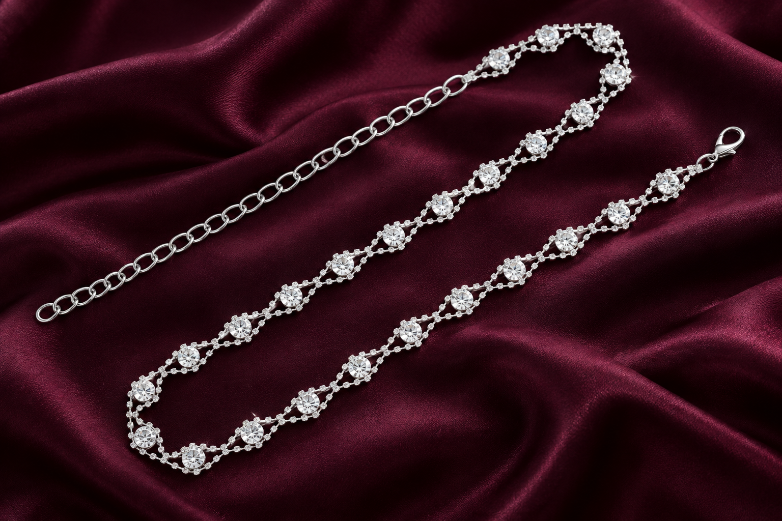 Abien-inspired silver crystal chain arranged on plum satin, an editorial composition